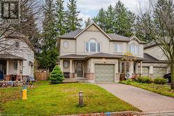 View of front of home with a front yard, ac unit, and a garage - 