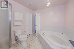 Bathroom featuring toilet and tiled tub - 