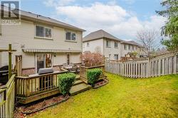 Back of property featuring a wooden deck and a yard - 