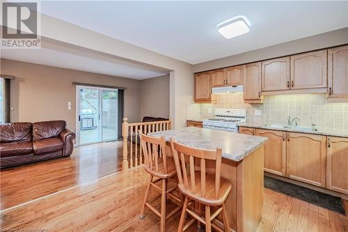 Kitchen with a breakfast bar, white gas stove, a kitchen island, and light hardwood / wood-style flooring - 435 Shadow Wood Crescent, Waterloo, ON - Indoor Photo Showing Other Room