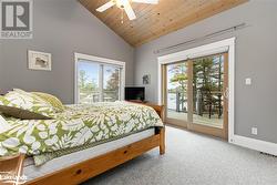 Bedroom with access to outside, multiple windows, ceiling fan, and wood ceiling - 