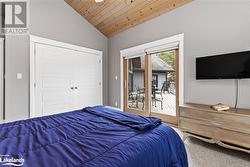 Carpeted bedroom featuring a closet, wooden ceiling, access to outside, and vaulted ceiling - 