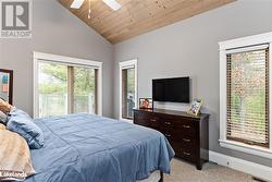 Carpeted bedroom featuring ceiling fan, wooden ceiling, and high vaulted ceiling - 