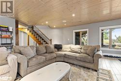 Living room featuring wood ceiling and light wood-type flooring - 