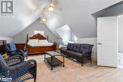 Bedroom featuring light wood-type flooring, vaulted ceiling, and ceiling fan - 