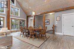 Dining room featuring high vaulted ceiling, wooden ceiling, and light wood-type flooring - 