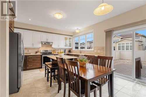 Grand Modern Kitchen with Patio Doors to the PVC Fenced Backyard - 379 Andalusian Crescent, Kanata (9010 - Kanata - Emerald Meadows/Trailwest), ON - Indoor Photo Showing Dining Room