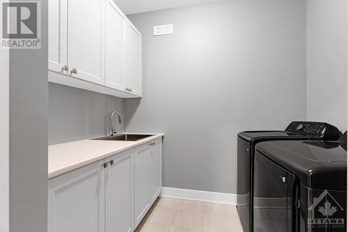 Laundry room with sink and storage cabinets - 11 New Haven Gate, Westport, ON - Indoor Photo Showing Laundry Room