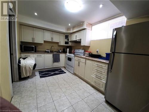 Kitchen with light stone countertops, sink, light tile patterned floors, and appliances with stainless steel finishes - 12 Peer Drive Unit# Basement, Guelph, ON - Indoor Photo Showing Kitchen