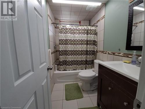 Full bathroom with tile patterned floors, vanity, shower / tub combo with curtain, tile walls, and toilet - 12 Peer Drive Unit# Basement, Guelph, ON - Indoor Photo Showing Bathroom