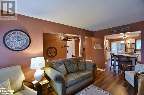 Living room with hardwood / wood-style flooring, a notable chandelier, and a barn door - 97 Glen Eton Road, Wasaga Beach, ON 