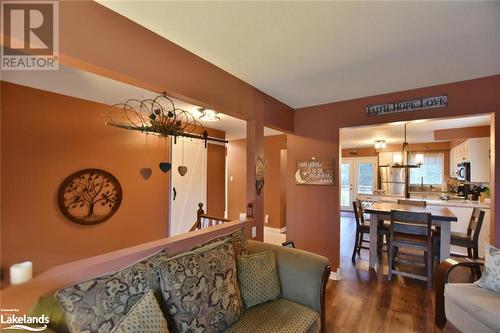 Living room featuring a barn door, wood-type flooring, and a notable chandelier - 97 Glen Eton Road, Wasaga Beach, ON 