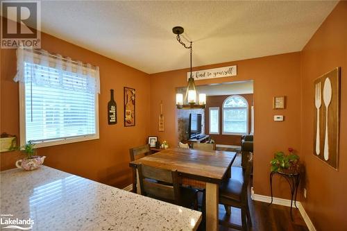 Dining area featuring a chandelier, a textured ceiling, dark hardwood / wood-style floors, and a healthy amount of sunlight - 97 Glen Eton Road, Wasaga Beach, ON 