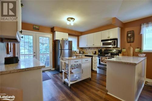 Kitchen featuring a wealth of natural light, white cabinetry, dark wood-type flooring, and appliances with stainless steel finishes - 97 Glen Eton Road, Wasaga Beach, ON 