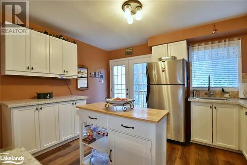 Kitchen featuring stainless steel fridge, a healthy amount of sunlight, and dark hardwood / wood-style floors - 97 Glen Eton Road, Wasaga Beach, ON 