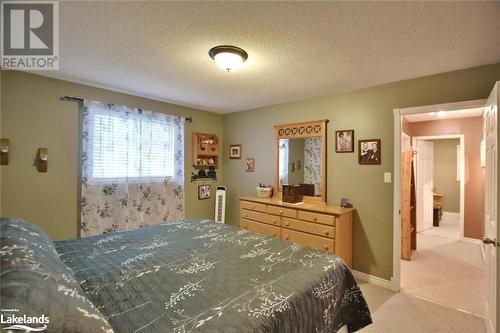 Bedroom with a textured ceiling and light carpet - 97 Glen Eton Road, Wasaga Beach, ON 