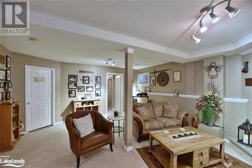 Carpeted living room featuring ceiling fan and a textured ceiling - 97 Glen Eton Road, Wasaga Beach, ON 