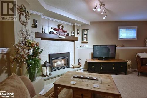 Carpeted living room with a textured ceiling and a fireplace - 97 Glen Eton Road, Wasaga Beach, ON 