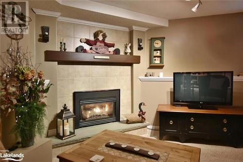 Living room with a fireplace, carpet, a textured ceiling, and ornamental molding - 97 Glen Eton Road, Wasaga Beach, ON 