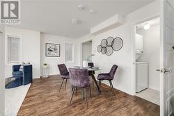 Dining space featuring hardwood / wood-style flooring and stacked washer / dryer - 