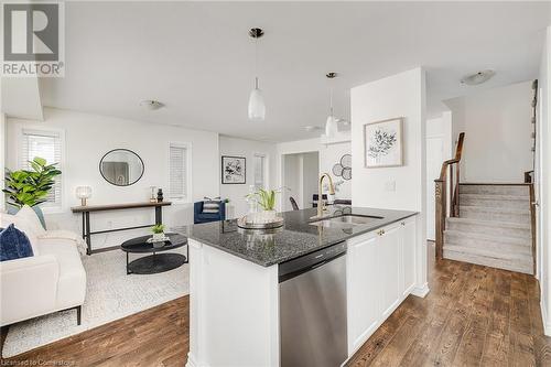 Kitchen featuring hanging light fixtures, dark hardwood / wood-style flooring, sink, and stainless steel dishwasher - 577 Goldenrod Lane, Kitchener, ON - Indoor Photo Showing Kitchen With Upgraded Kitchen