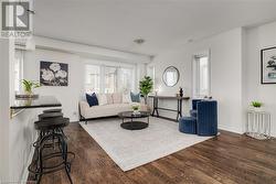 Living room with dark hardwood / wood-style floors and plenty of natural light - 