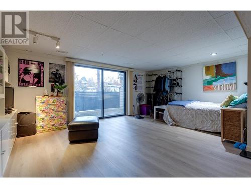 Lower level bedroom with access to privately fenced patio - 1675 Thayer Court Unit# 11, Kelowna, BC - Indoor Photo Showing Bedroom