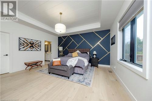 Bedroom with hardwood / wood-style flooring, connected bathroom, and a tray ceiling - 33 Madwayosh Street, Southampton, ON - Indoor Photo Showing Bedroom