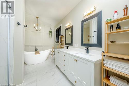 Bathroom with a bathtub, vanity, and an inviting chandelier - 33 Madwayosh Street, Southampton, ON - Indoor Photo Showing Bathroom