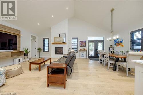 Living room with french doors, high vaulted ceiling, light hardwood / wood-style floors, and a brick fireplace - 33 Madwayosh Street, Southampton, ON - Indoor With Fireplace