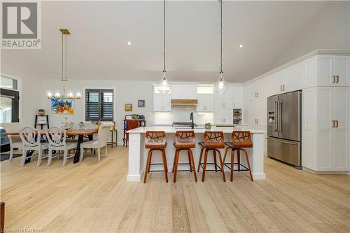 Kitchen featuring high quality fridge, white cabinetry, light hardwood / wood-style flooring, and pendant lighting - 33 Madwayosh Street, Southampton, ON - Indoor