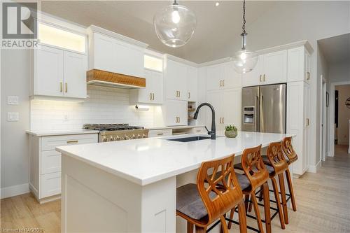 Kitchen with white cabinetry, sink, stainless steel appliances, a center island with sink, and light wood-type flooring - 33 Madwayosh Street, Southampton, ON - Indoor Photo Showing Kitchen With Upgraded Kitchen