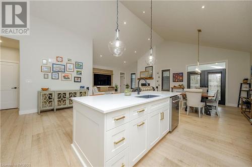 Kitchen with white cabinetry, a kitchen island with sink, hanging light fixtures, and light hardwood / wood-style floors - 33 Madwayosh Street, Southampton, ON - Indoor Photo Showing Kitchen