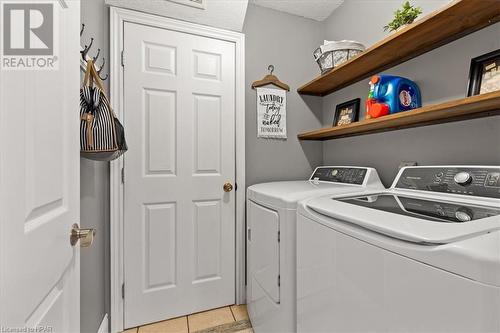 Laundry area featuring separate washer and dryer, a textured ceiling, and light tile patterned floors - 830 Elma Street W, Listowel, ON - Indoor Photo Showing Laundry Room