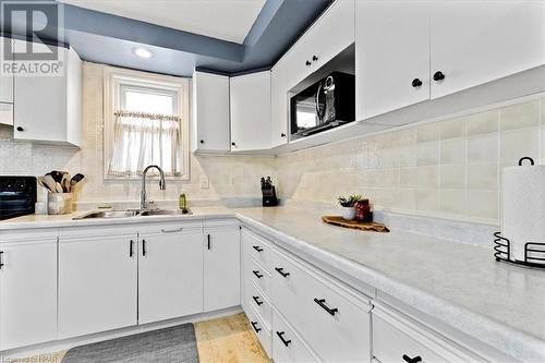 Kitchen featuring backsplash, white cabinetry, and sink - 830 Elma Street W, Listowel, ON - Indoor Photo Showing Kitchen With Double Sink