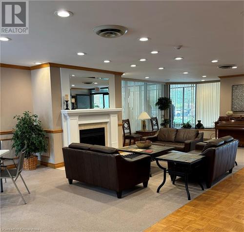 Resident's Lounge Area - 6 Willow Street Unit# #1505, Waterloo, ON - Indoor Photo Showing Living Room With Fireplace