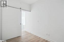 Spare room featuring a barn door and light wood-type flooring - 