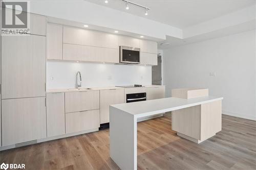 Kitchen with black oven, sink, a kitchen island, and light hardwood / wood-style floors - 370 Martha Street Unit# 2104, Burlington, ON - Indoor Photo Showing Kitchen With Upgraded Kitchen