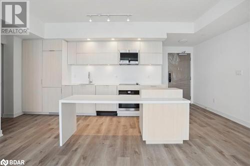 Kitchen featuring sink, a center island, light hardwood / wood-style flooring, and appliances with stainless steel finishes - 370 Martha Street Unit# 2104, Burlington, ON - Indoor Photo Showing Kitchen With Upgraded Kitchen