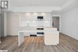 Kitchen featuring sink, a center island, light hardwood / wood-style flooring, and appliances with stainless steel finishes - 