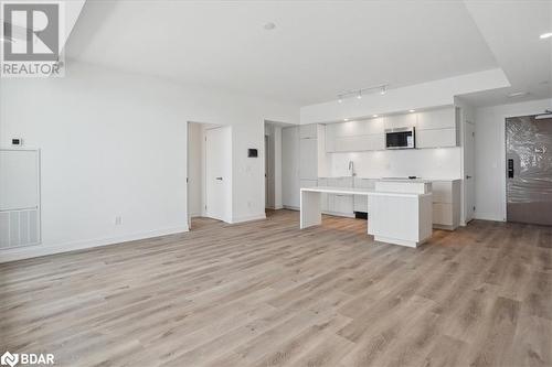 Kitchen with a kitchen island, light hardwood / wood-style floors, and track lighting - 370 Martha Street Unit# 2104, Burlington, ON - Indoor Photo Showing Kitchen