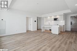 Kitchen with a kitchen island, light hardwood / wood-style floors, and track lighting - 