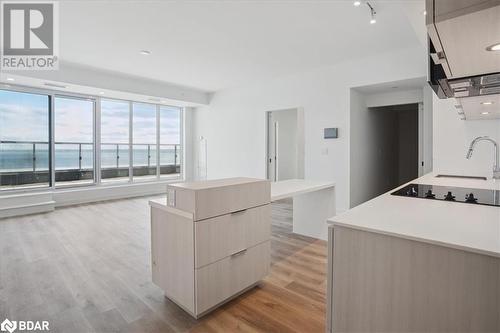 Kitchen with a center island, a water view, sink, light brown cabinetry, and light hardwood / wood-style floors - 370 Martha Street Unit# 2104, Burlington, ON - Indoor Photo Showing Other Room