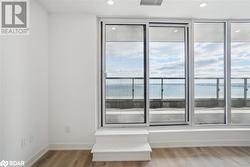 Unfurnished room featuring a water view and wood-type flooring - 