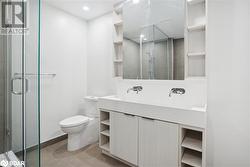 Bathroom with tile patterned floors, a shower with door, vanity, and toilet - 