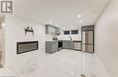 Kitchen with backsplash, gray cabinetry, sink, and stainless steel appliances - 1100 Union Street Unit# 3, Kitchener, ON - Indoor Photo Showing Kitchen