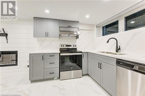 Kitchen featuring sink, gray cabinets, decorative backsplash, exhaust hood, and appliances with stainless steel finishes - 1100 Union Street Unit# 3, Kitchener, ON - Indoor Photo Showing Kitchen With Stainless Steel Kitchen With Double Sink