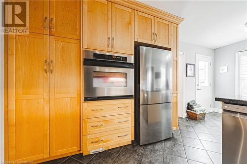 Kitchen with appliances with stainless steel finishes and dark tile patterned floors - 145 Dragoon Drive, Hamilton, ON - Indoor Photo Showing Kitchen