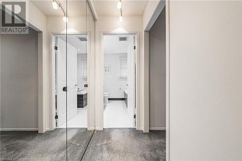 Hallway featuring dark colored carpet and a textured ceiling - 145 Dragoon Drive, Hamilton, ON - Indoor Photo Showing Other Room