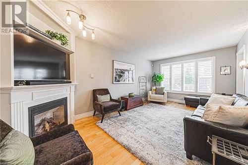 Living room with hardwood / wood-style floors and a textured ceiling - 145 Dragoon Drive, Hamilton, ON - Indoor Photo Showing Living Room With Fireplace